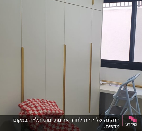ארון לבן עם ידיות זהב וסולם מתקפל